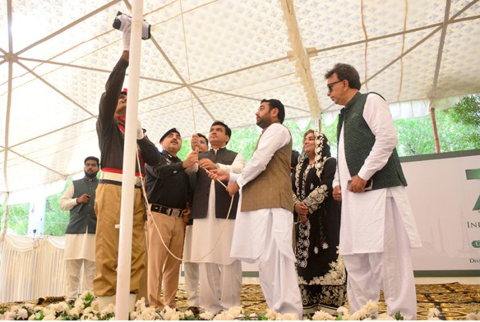 Commissioner Fayaz Abbasi with DC Zainul Abedin Memon hoisting Pakistan national flag during national flag hoisting ceremony during 78th Independence Day and Maarka-E-Haq celebrations at circuit house