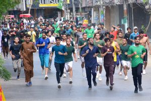 Workers of Sindh Solid Waste Management Board holding rally with displaying huge national flag during the 78th Independence Day and Maarka-E-Haq celebrations at Radio Pakistan Road