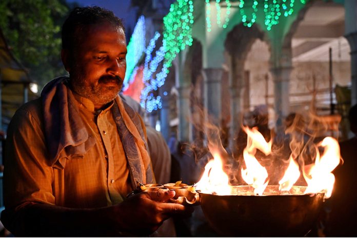 Worshipers lit-up earth lamps at Data Darbar during the 982nd Urs celebration of Data Ali Hajveri while a large number of people arrive to attend the three-day celebrations