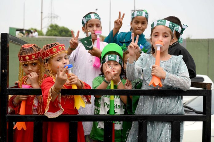 Children wearing dresses, caps in the national flag color celebrate the 78th Independence Day of Pakistan and Maarka e Haq