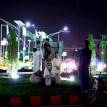 A man captures picture of his children with the well decorated buildings of Aiwan e Sadr and Parliament House in national celebration with the theme of “Maarka-e-Haq” (Struggle for Right) profoundly resonant for Pakistan’s Independence Day