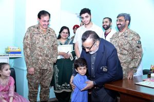 Managing Director Pakistan Bait-ul-Mal Senator Capt. Shaheen Khalid Butt talking to a child after his PBM-funded Cochlear Implant Surgery at CMH