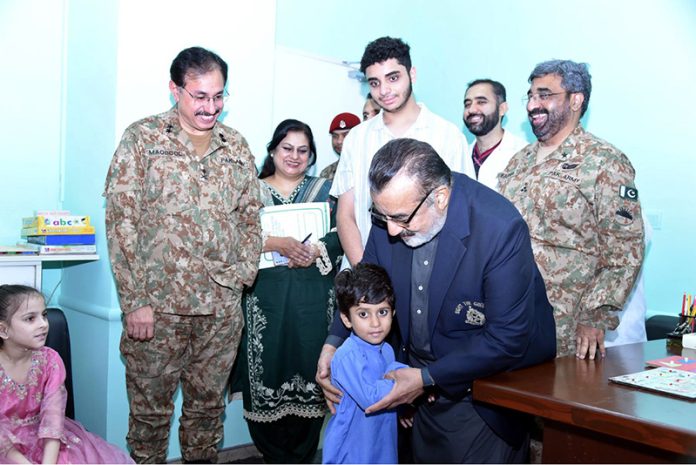 Managing Director Pakistan Bait-ul-Mal Senator Capt. Shaheen Khalid Butt talking to a child after his PBM-funded Cochlear Implant Surgery at CMH