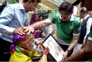 Sindh Chief Minister Syed Murad Ali Shah gently greets a differently-abled girl during his visit to a stall at the Grand Festival for Special Children, organised by the DEPD at Al-Noor Park, Clifton