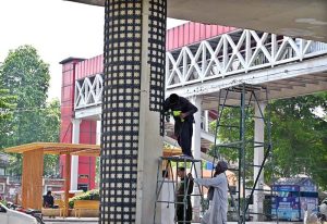 PHA workers are busy decorating the pillars of the metro bus track on Murree Road to beautify the city.