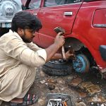 A mechanic is busy to repairing vehicle at his workshop in Federal Capital