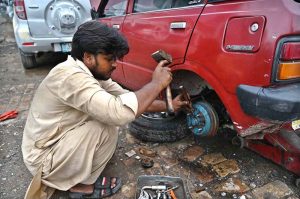 A mechanic is busy to repairing vehicle at his workshop in Federal Capital