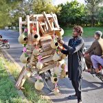 A vendor displaying bird’s nests and wooden base stand for refrigerator on his bicycle to attract the customers in Federal Capital