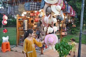 A young girl shows a keen interest in caps displays on a stall at Lake View Park