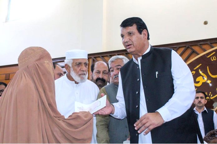 Federal Minister for Kashmir Affairs, Gilgit Baltistan and SAFRON Engr Amir Muqam and Special Assistant to Prime Minister Talha Burki distributing relief cheques among the victims of the recent torrential rains and floods