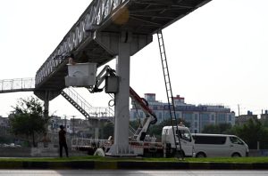 WAPDA workers busy installing electricity cables on the steel electric bridges along the Expressway.