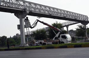 WAPDA workers busy installing electricity cables on the steel electric bridges along the Expressway.