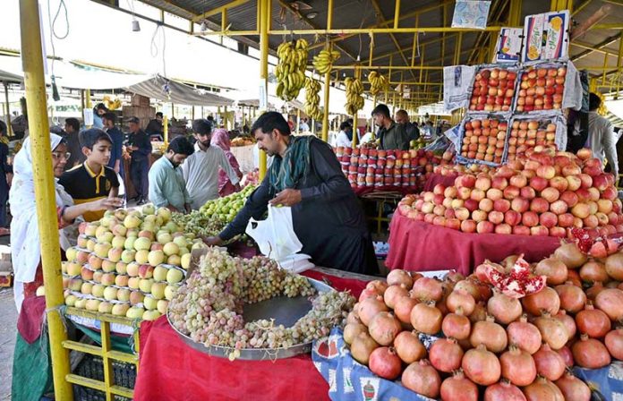 A vendor sells seasonal fruit at his stall in weekly Sunday Bazaar in G-6 Sector in the Federal Capital