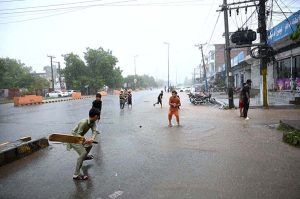 Children are enjoying in the street during rain that experienced the city