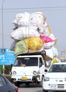 A view of a loader van heavily loaded with scrap, posing the risk of an accident and requiring attention from the concerned authorities in the Federal Capital.