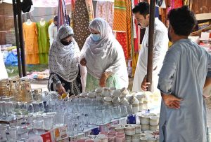 A family selects tea cups and glass from a stall displayed by a vendor at the I-9/4 weekly bazaar in the Federal Capital.