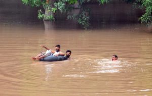 Flood-affected villagers wade through the flood waters toward the safe place
