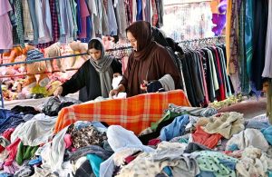 Women selects and purchases used cloth pieces from the I-9/4 weekly bazaar in the Federal Capital.