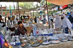 A family selects tea cups and glass from a stall displayed by a vendor at the I-9/4 weekly bazaar in the Federal Capital.