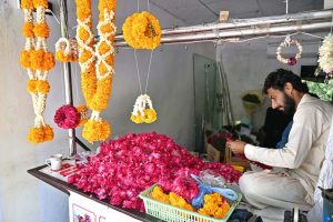 A vendor busy preparing flower garlands to attract the customers at Supper Market in Federal Capital.