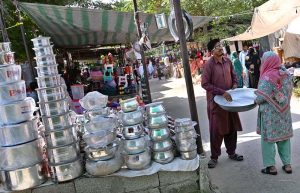 A family selects tea cups and glass from a stall displayed by a vendor at the I-9/4 weekly bazaar in the Federal Capital.