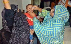 A health worker busy in administering polio drops to child during anti polio campaign in Bhitai Hospital at Latifabad.