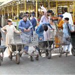 Labourers with their handcarts wait for customers to shift luggage in the G-6 weekly Bazaar in the Federal Capital