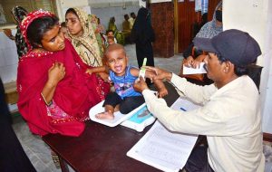 A health worker busy in administering polio drops to child during anti polio campaign in Bhitai Hospital at Latifabad.