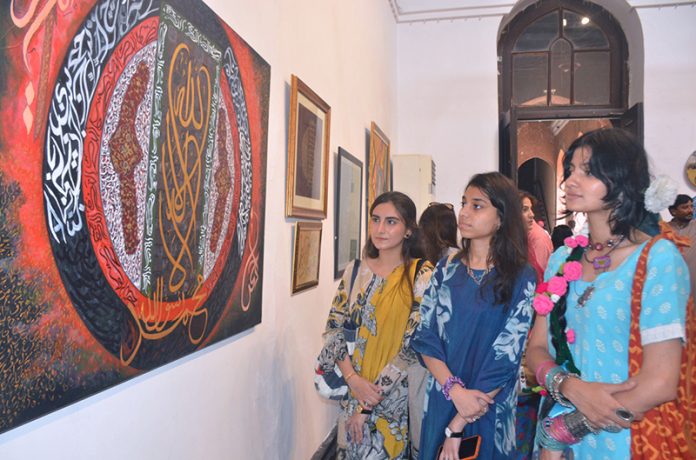 Women art enthusiasts keenly observe masterpieces of artist during a calligraphy exhibition organized to mark Eid Milad-un-Nabi (PBUH) celebrations
