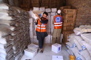 Workers of the Alkhidmat Foundation load relief goods onto delivery trucks in Chamkani to dispatch to flood-affected people in Punjab.