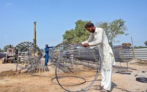 Labourers are busy preparing iron structures for the pillars during the construction of the T-Chowk Flyover, which is part of the ongoing development work