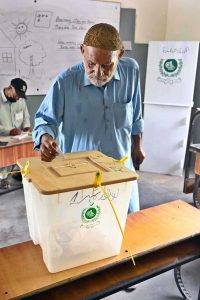 A woman casts her vote at a polling station during the Local Government by-election in UC 112, Latifabad.