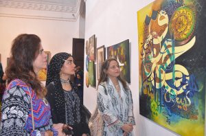 Women art enthusiasts keenly observe masterpieces of artist during a calligraphy exhibition organized to mark Eid Milad-un-Nabi (PBUH) celebrations