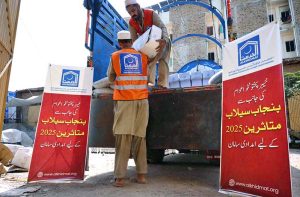 Workers of the Alkhidmat Foundation load relief goods onto delivery trucks in Chamkani to dispatch to flood-affected people in Punjab.