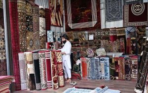A vendor displays different carpets to attract the customers in Sunday Bazaar at Peshawar Morr.