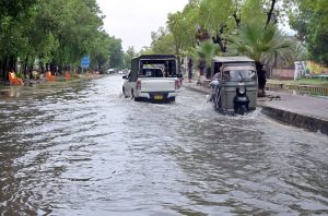 Vehicles navigate through flooded streets after heavy rain at Thandi road in the city .