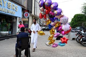 A street vendor displaying various colorful balloons to attract customers at the roadside.