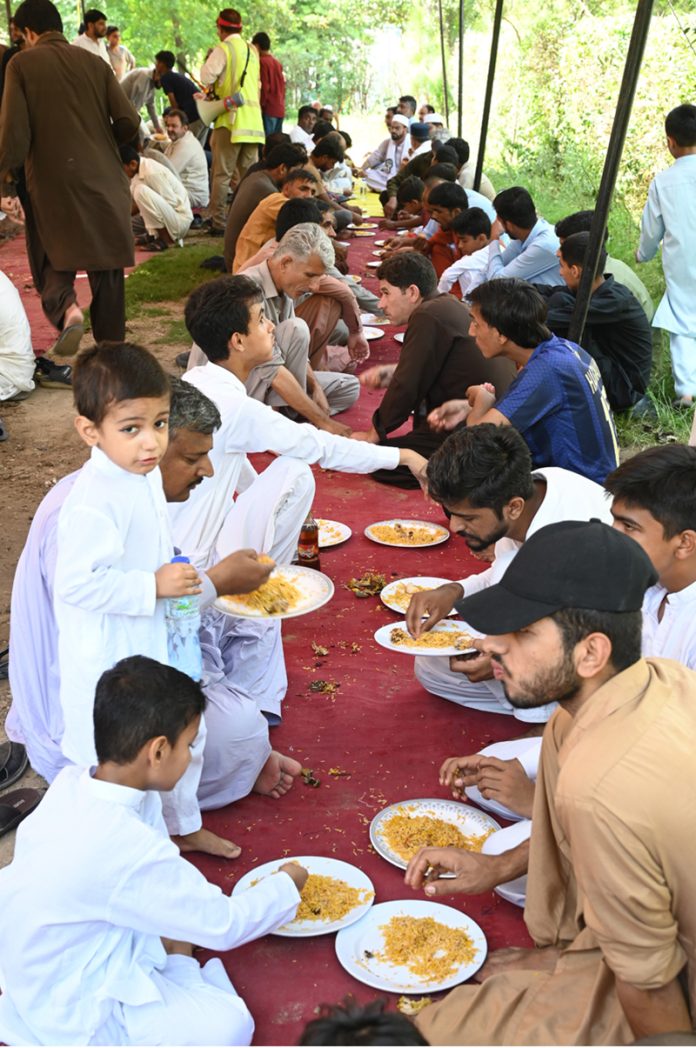 Volunteers serving free food to the participants of the Eid Milad Un Nabi (PBUH) procession at G-7 area in the federal capital