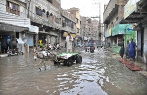 Vehicles navigate through flooded streets after heavy rain at Thandi road in the city .