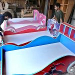 Vendors are displaying a variety of children's beds to attract customers at their shop in New Katarian