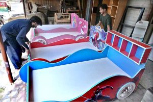 Vendors are displaying a variety of children's beds to attract customers at their shop in New Katarian