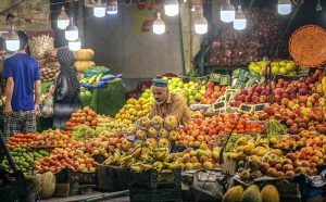 A vendor arranging and displaying different kinds of fruits to attract the customers at Khanna Pul.