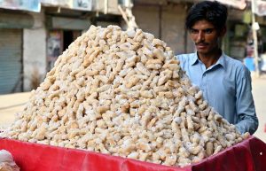 A street vendor selling crispy rice flour sticks, a traditional sweet, at Naudero Chowk.