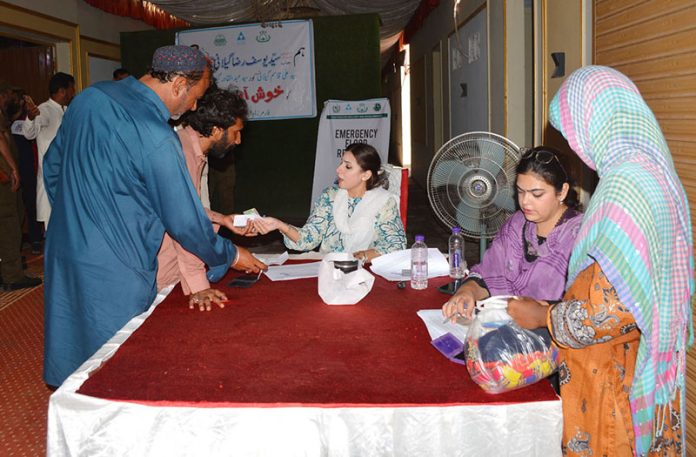 Flood-affected being registered during the distribution ceremony of essential relief packages among flood-affected families of Union Council Sher Shah organized by farmer development organization, collaboration with the Pakistan poverty Alleviation fund at a local hall