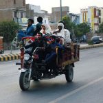 Flood-affected people load their belongings onto tricycles as they migrate to safer areas from inundated localities after deadly flash flood hit Bahawalpur