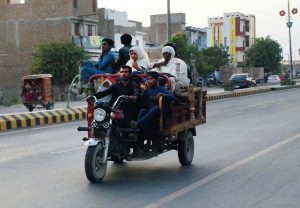 Flood-affected people load their belongings onto tricycles as they migrate to safer areas from inundated localities after deadly flash flood hit Bahawalpur