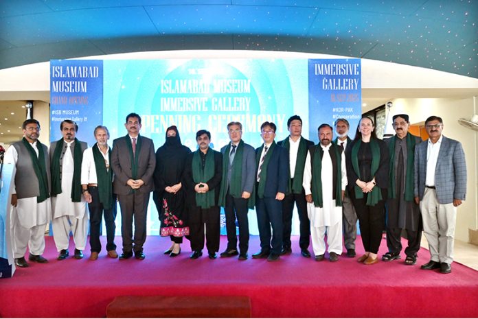 Minister of State for National Heritage & Culture Division Huzifa Rehman in a group photograph during opening ceremony of Digital Immersive Gallery at Islamabad Museum