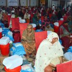Flood-affected households sitting with their essential relief packages during a distribution ceremony at a local hall in Union Council Sher Shah, organized by the Farmer Development Organization in collaboration with the Pakistan Poverty Alleviation Fund