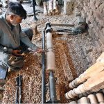 A carpenter skillfully carves designs on the pieces of traditional wooden bed "Charpai" at his workplace.