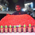A vendor displays freshly served red pomegranate seeds in disposable glasses with spoons on his handcart to attract customers at Gul Center